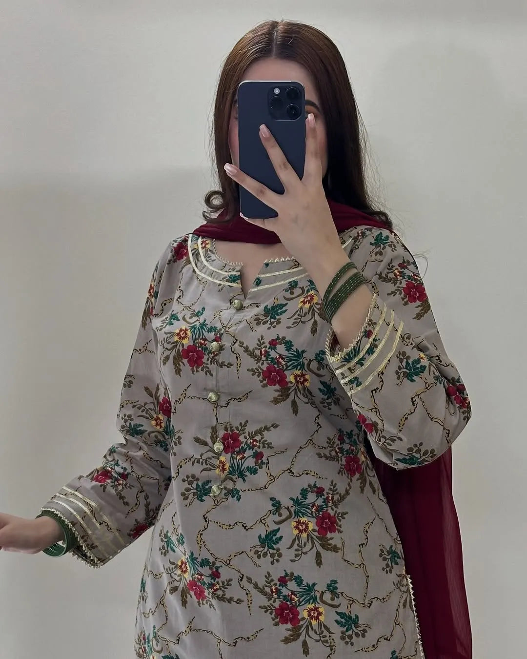 Woman wearing a floral embroidered dress with a plain background