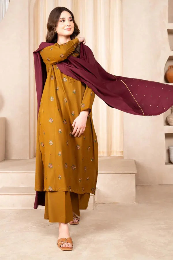 Woman wearing a mustard yellow outfit with a maroon dupatta in an indoor setting
