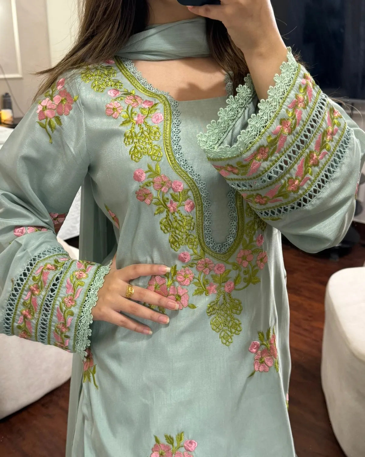 Light blue embroidered dress with floral patterns worn by a person indoors.