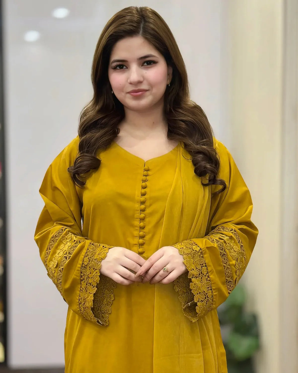 Woman wearing a yellow outfit with lace details indoors