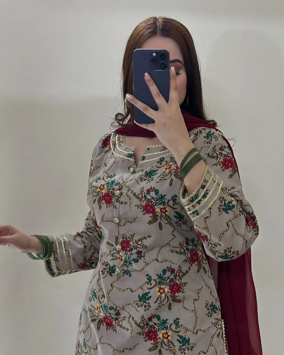 Person wearing a floral embroidered outfit with a plain background