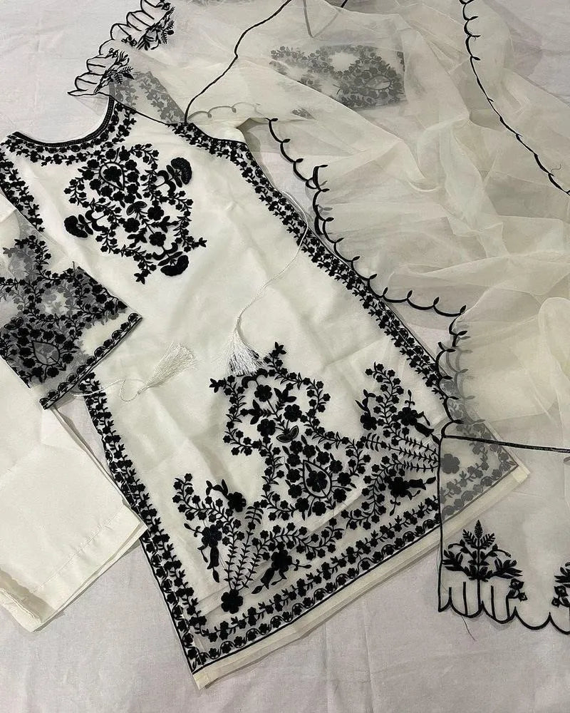 White fabric with black floral embroidery on a light gray background