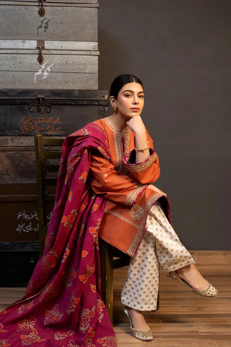 Woman in traditional attire sitting on a wooden chair with a textured wall background