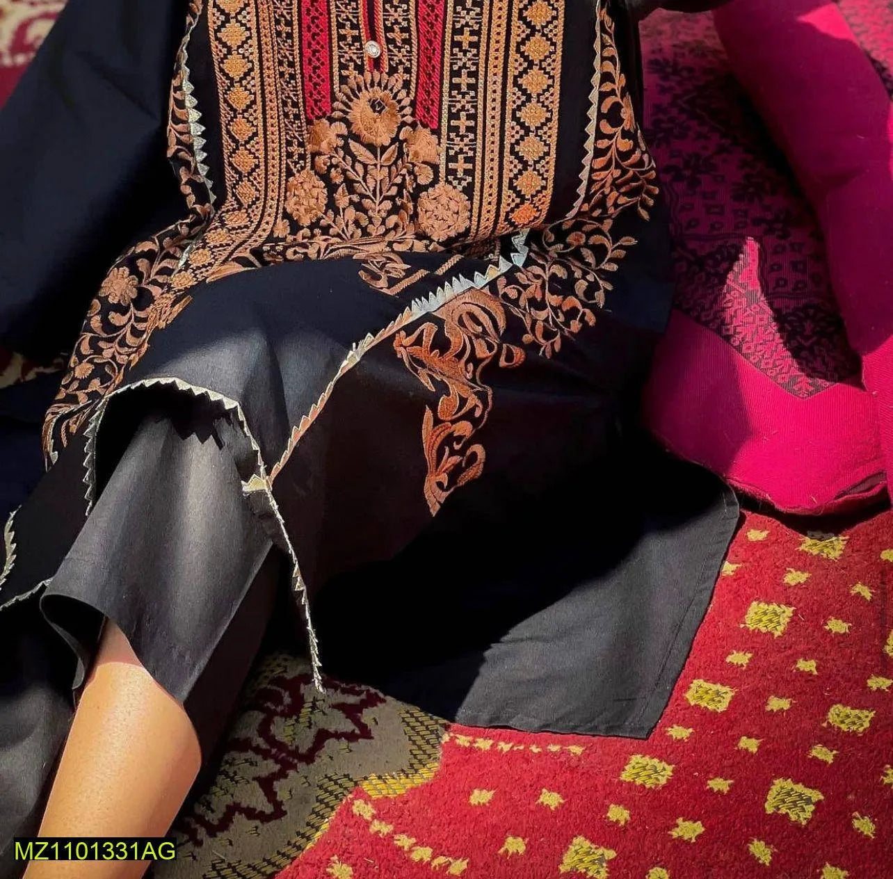 Traditional embroidered fabric with intricate patterns on a red and gold background